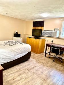 a hotel room with a bed and a desk and a television at Wickford Motor Inn in North Kingstown