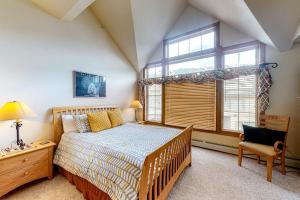 a bedroom with a bed and a window and a chair at Ski Den #22 in Copper Mountain