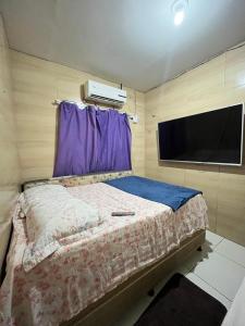 a bedroom with a bed and a flat screen tv at Casa completa Janga in Paulista
