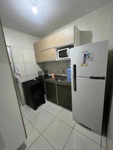 a small kitchen with a refrigerator and a stove at Casa completa Janga in Paulista