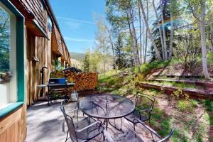 a patio with a table and chairs and a grill at Cozy Condo on Chamonix Lane in Vail