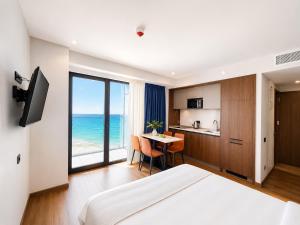 a bedroom with a bed and a table with a view of the ocean at Signature Residence Sea View Suites in Marriott Privilege in Batumi