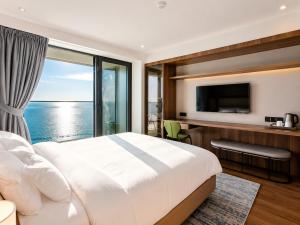 a bedroom with a large bed and a large window at Signature Residence Sea View Suites in Marriott Privilege in Batumi