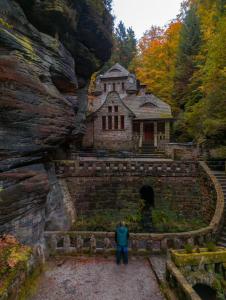 a man is standing in front of a building at Wellness Hotel Praha in Hřensko