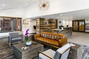 a lobby with a leather couch and a table and chairs at Torian Plum Plaza 302 in Steamboat Springs