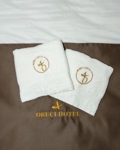 two white towels sitting on top of a bed at Oruci hotel in Kukës