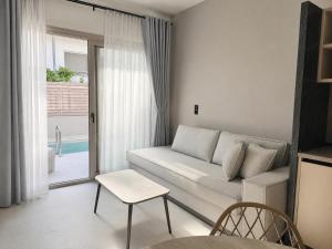 a living room with a couch and a table at LaK Private Pool Suites in Potos,Thassos in Potos