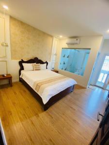 a bedroom with a large bed and a large window at khách sạn Quốc Tế in Cà Mau