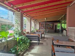 a restaurant with tables and chairs and plants at Hotel Mandarin in Ureki