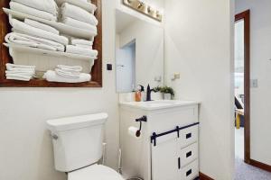 a bathroom with a toilet and a mirror and towels at Skiing Sanctuary in Winter Park +36 photos