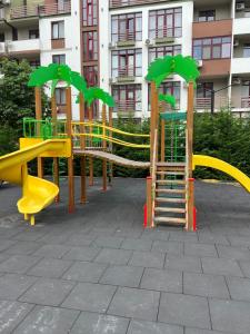 a playground with a yellow slide in a park at Квартира-студія in Odesa