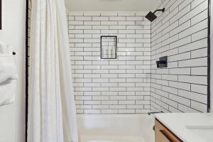 a white tiled bathroom with a shower and a tub at The Golden Moose Chalet in Grand Lake +39 photos