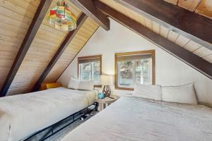 two beds in a room with two windows at The Golden Moose Chalet in Grand Lake