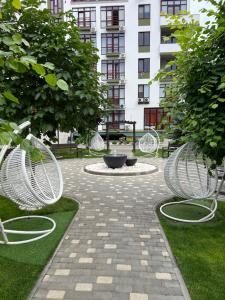 a park with two white chairs and a fountain at Квартира-студія in Odesa