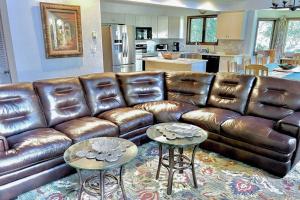 a brown leather couch in a living room with two tables at Alpine Bliss in Durango
