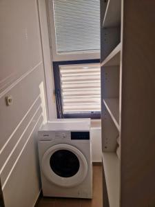 a washing machine in a small room with a window at Studio apartman Picok Đurđevac in Ðurđevac