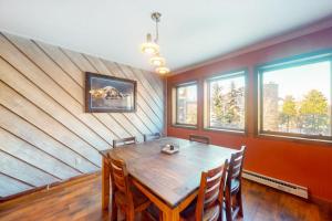 a dining room with a wooden table and some windows at Basking in Breckenridge Brilliance in Breckenridge