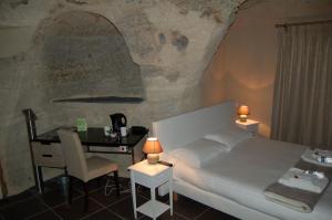 - une chambre avec un lit, une table et un bureau dans l'établissement Rocaminori Hôtel, à Louresse-Rochemenier