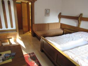 a living room with a bed and a couch at Waldpension Reisinger in Fladnitz an der Teichalm