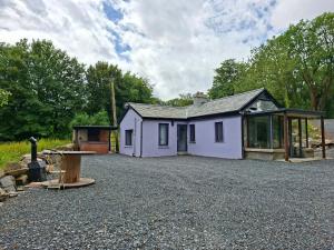 a purple house in a gravel parking lot at Lakelands Cottage in Nenagh