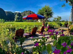 a patio with a table and chairs and an umbrella at Tam Coc Mountain View Homestay in Ninh Binh