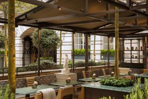 an outdoor patio with tables and chairs and plants at Rosewood London in London +76 photos