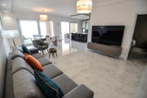 a living room with a couch and a flat screen tv at B6 Dahlet Ta Cenc in Sannat