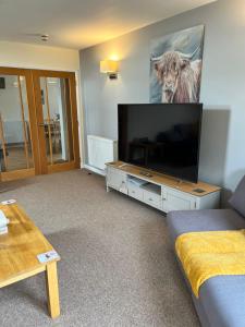 a living room with a large flat screen tv at Seaview Apartment in Keiss