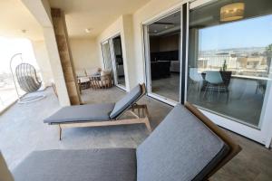 a living room with a couch and a chair on a balcony at B6 Dahlet Ta Cenc in Sannat