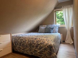 a bedroom with a bed and a window at Ferienwohnung Blumenthal bei Kiel in Blumenthal