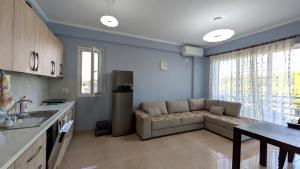 a kitchen with a couch in the middle of a room at Sophi's Dream Apartment in Lalzit Bay