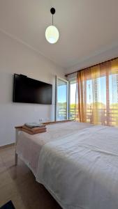 a bedroom with a large bed and a large window at Sophi's Dream Apartment in Lalzit Bay