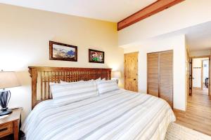 a bedroom with a large bed with a wooden headboard at Coziest Condo in Winter Park +69 photos