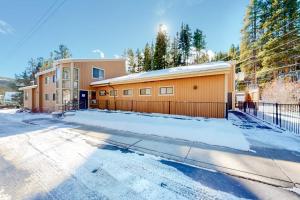 a building with a fence in the snow at Coziest Condo in Winter Park