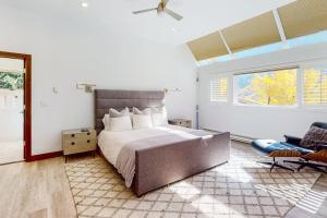 a bedroom with a bed and a chair and a window at Unveil Vail in Vail