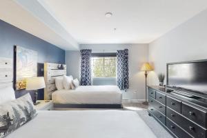 a bedroom with two beds and a flat screen tv at First Tracks 4202 in Steamboat Springs +73 photos