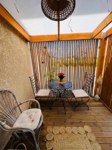 a patio with a table and chairs on a wooden deck at Le Boudoir, inclus petit déjeuner in Quincié-en-Beaujolais
