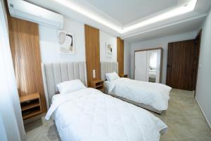 a bedroom with two beds with white sheets at Residence vigier in Tangier