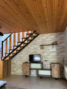 a room with a brick wall with a staircase at Levani's Cottage in Borjomi +9 photos