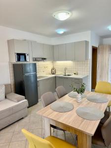una cucina con un tavolo di legno e una cucina con un frigorifero di Apartmani Samec a Novalja (Novaglia)
