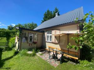 a small house with a table and chairs in the yard at Bezvējš in Jūrmala