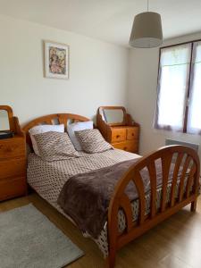 a bedroom with a large wooden bed and a window at Maison Vexin in Boury-en-Vexin