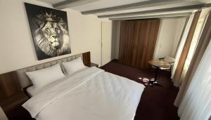 a bedroom with a bed with a lion picture on the wall at Hotel am Kocher in Schwäbisch Hall