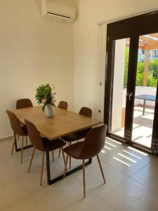 a dining room with a wooden table and chairs at CasaKOS in Kos +26 photos