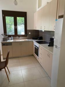 a kitchen with white cabinets and a white refrigerator at CasaKOS in Kos
