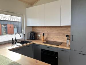 a kitchen with white cabinets and a sink at Fernblick- Sauna- WLAN- Haus 2 in Neheim-Hüsten