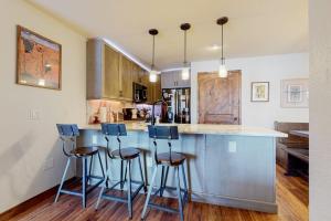 a kitchen with a counter and stools at a bar at Frisco Home Base in Frisco