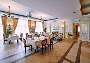 jadalnia z białymi stołami i krzesłami w obiekcie Villa Royal w Ostrowie Wielkopolskim