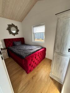 a red bed in a room with a window at Fernblick- Sauna- WLAN- Haus 2 in Neheim-Hüsten