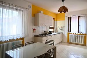a kitchen with yellow walls and a table and chairs at Maison Josephine in Chiusa di Pesio